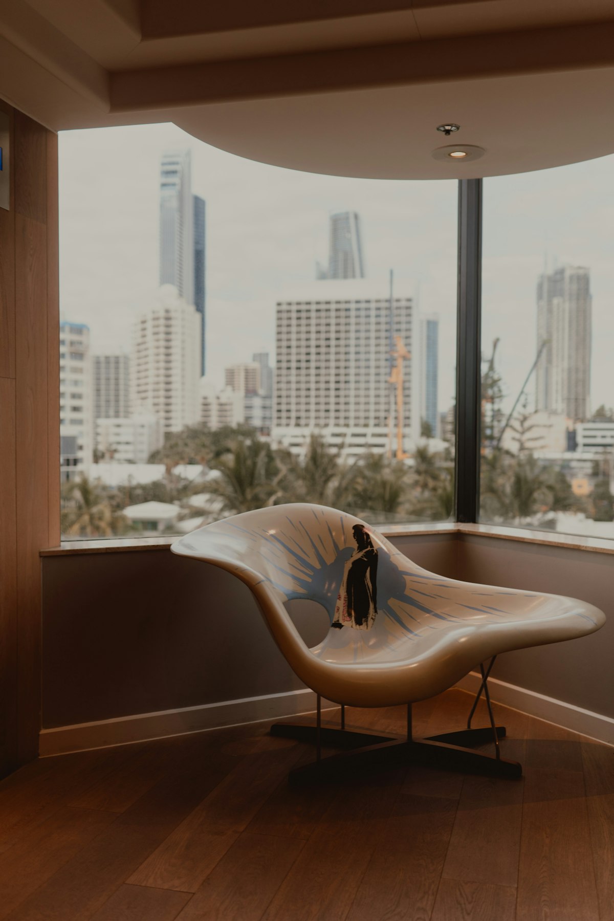A lounge chair by a window overlooking a city skyline